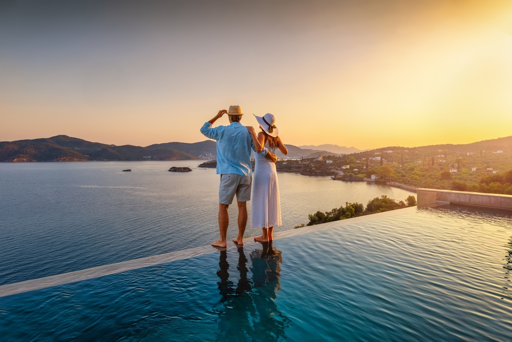 Couple looking out at sunset over the Mediterranean from a hotel balcony
